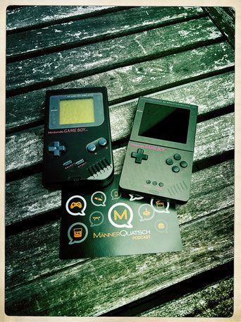 Das Titelbild zu Männerquatsch Podcast Folge 144 (Analogue Pocket FPGA Handheld Erfahrungsbericht) zeigt einen DMG Game Boy in Schwarz der Play it Loud Serie neben einem Analogue Pocket mit schwarzen Aufklebern.