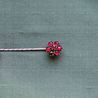 photo of garnet stick pin on green dupioni silk cloth