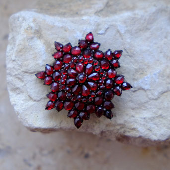 photo of garnet brooch on stone