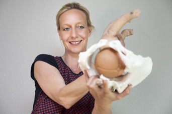 Hebamme Katharina Jeschke zeigt am Beckenmodell, wie ein Baby geboren wird.