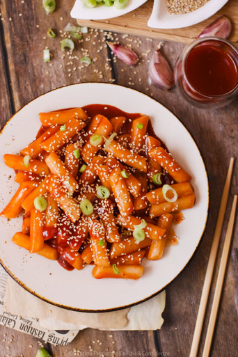 gnocchi di riso con salsa piccante e semi di sesamo tostati, tipici della cucina coreana