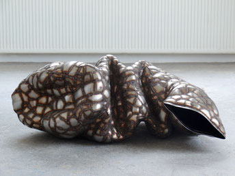 zeitgenössische Skulptur von Andreas Jonak, auf dem Boden liegende Edelstahlskulptur mit Schweißnähren netzartig überzogen und bunten Rändern. blasenartige reflektierende Oberfläche