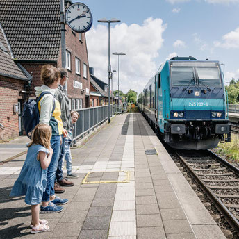 Familie am Bahnhof Klanxbüll, einfahrender Zug nach Sylt