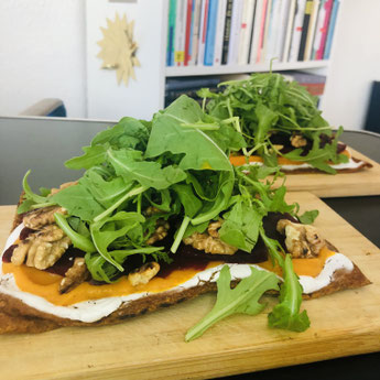 Veganer Flammkuchen mit orangener Süßkartoffelcreme, getippt mit Roter Beete, Walnüssen und grünem Rucula.