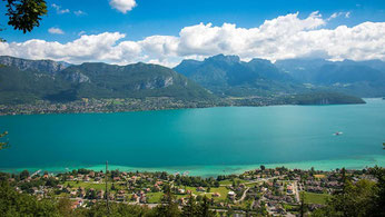Vue sur le lac d'annecy et ses eaux turquoise avec les montagnes en arrière plan