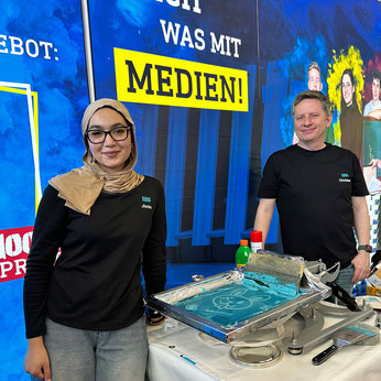 Christian Roos and apprentice media technologist screen printing at fitforJob! Trade Fair in Augsburg 