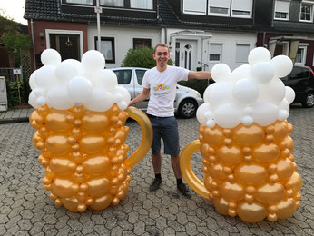 Ballonkünstler Marvin Ohmstedt mit zwei Bierkrügen aus Luftballons