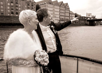 Hochzeit auf der Nedeva, Portraitaufnahme auf dem Schiff Vorderdeck, Blick in Richtung Staphanibrücke in Bremen, Bräutigam zeigt mit Hand Richtung Beck´s Bremen