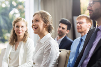 Lächelnde Frau sitzt im Seminar Publicum
