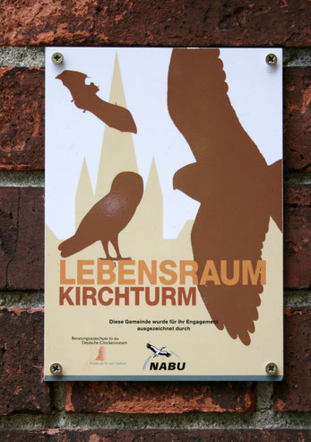 Plakette "Lebensraum Kirchturm" an einer Kirchenmauer