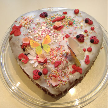 Herzförmiger Kuchen mit Marienkäfer und Schmetterlingen als Dekoration