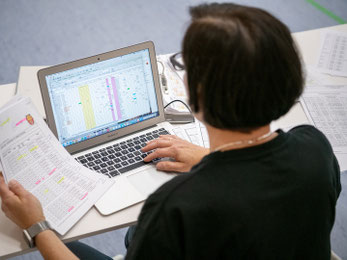 Frau am PC beim Ausfüllen einer Tabelle