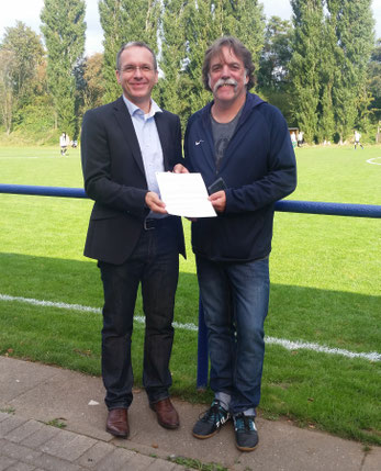 André Dora und Martin Kindermann halten den Pachtvertrag in ihren Händen, der heute bei de Heimspiel unserer ersten Mannschaft übergeben wurde.