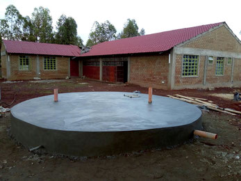 The house with the open roof. The water storage in the foreground...