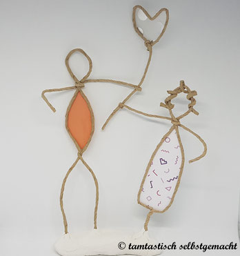 Papierdrahtfigur-Pärchen-Mann-und-Frau-halten-gemeinsam-ein-transparentes-Herz