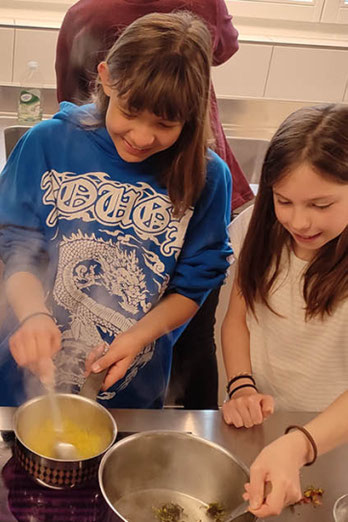 Kinder beim Kochen in der Lagerküche - beim Kinderlager Erlebnis Kochen wird gemeinsam die Küche zum Erlebnisort