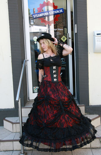 Eine stolze Kundin im fertigen Steampunk-Outfit vor dem Eingang der Steampunk-Station in Bochum