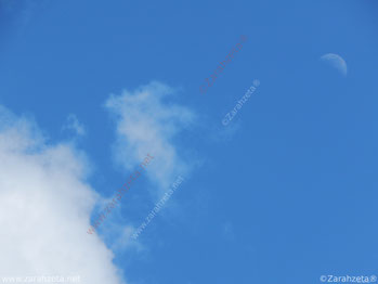Mond und Wolken am blauen Himmel