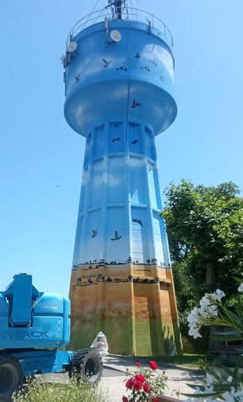 fresque sur le château d'eau de Bouglon représentant paysage, ciel, palombes réalisé par l'artiste Coron Thibaud, ciel, oiseaux