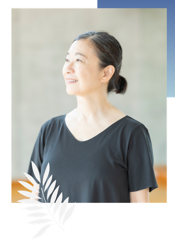 講師 荒藤が、スタジオから空を見上げています。明るい日差しに照らされて、ほほ笑んでいます。