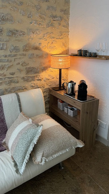 Espace de repos avec fauteuil, lampe et machine à café dans la chambre d’hôtes Le Jardin à Meursault