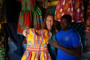 Trying on a colorful dress at the Sucupira market in Praia, Santiago