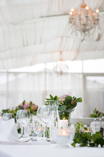 <img src=“Bilddatei.jpg“ alt=Brauttafel im Festzelt mit Dekoration aus Blumen und Kerzen>