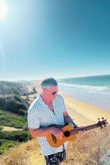 Bass-Ukulele am Strand im Sand – ideal als Reise-Bass zum Üben