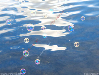 Bunte Seifenblasen auf Wasseroberfläche
