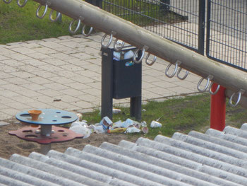 Vermüllte Mülltonne auf dem Kinderspielplatz