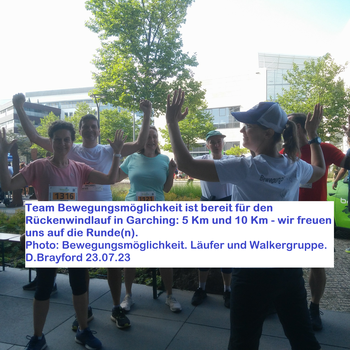 Drei Sportlerinnen und zwei Sportler stehen vor Stefanie, die mit dem Rücken zum Bild steht (man kann das Logo "Bewegungsmöglcihkeit auf dem T Shirt sehen). Alle heben die Arme und lächeln. Ein Textfeld beschreibt das Bild. Foto wurde von D. Brayford gema