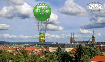 Heissluftballon mit Ballongasfüllung fliegt mit einem Frosch über Bamberg hinweg