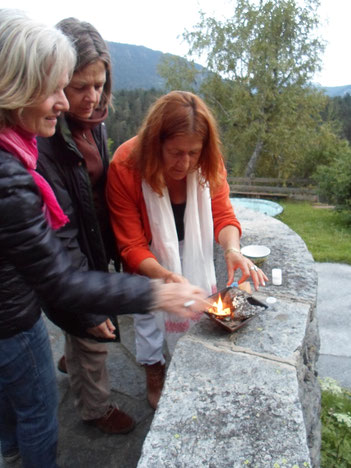 Marianne Scherer und zwei Frauen zünden das Feuer in einem kleinen Agnihotra-Topf an