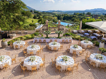 Feierlich gedeckte Hochzeitstische unter freiem Himmel in der Toskana mit stimmungsvoller Atmosphäre