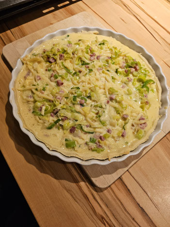 Quiche Lorraine in einer Tarteform bereit zum Backen