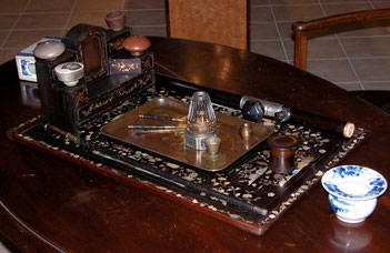 Plateau portant un nécessaire de fumeur d'opium complet : pipe, lampe, fourneaux, outils et ringard.