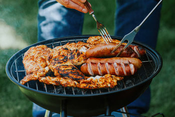 Fleisch und Würstel auf einem Kugelgriller