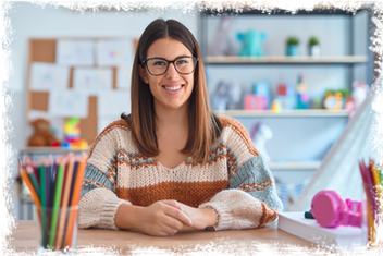 Junge Frau mit Brille an einem Tisch mit Buntstiften, Stelle als stellvertretende Leitung bei den Glückskindern