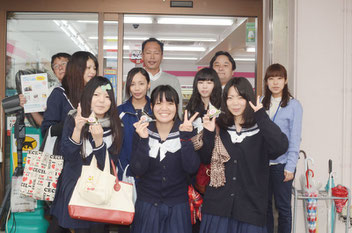 発売されるおにぎりを手にする(前列右から)比嘉さん、新城さん、木村さん。後列は、高校生を応援する長嶺勉店長(左端)ら=ココストア石垣市役所前店、23日
