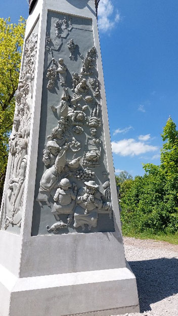 Das Denkmal besteht aus einer Säule mit einem Relief.
