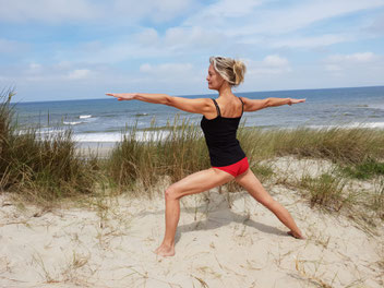 Mieke beoefent yoga op het strand