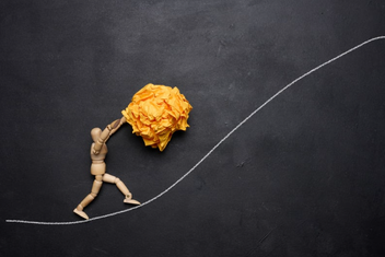 Hier sieht man eine Figur einen Ball den Berg hochschieben. @Canva