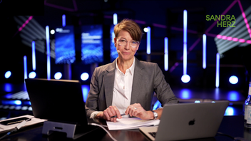 A photo of Sandra Herz moderating in an event setting