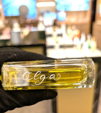 Live-Gravur eines Parfumflakons – der Name Olga wird per Fräser als individuelle Veredelung eingraviert, Schrift & Kunst by Sigrid Bengel