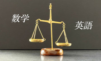 天秤の左右に「数学」「英語」と書かれた文字が配置された写真。主要科目のバランスを重視した学習戦略を表す指導方針イメージ