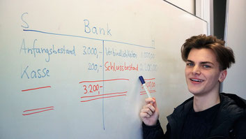 Im Berufskolleg Wirtschaftsinformatik lernt ein Schüler Buchhaltung und Rechnungswesen im BWL-Unterricht (Betriebswirtschaftslehre)