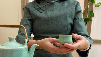 A cup of hot green tea with bamboo in the background