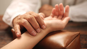 A TCM doctor performs a pulse diagnosis