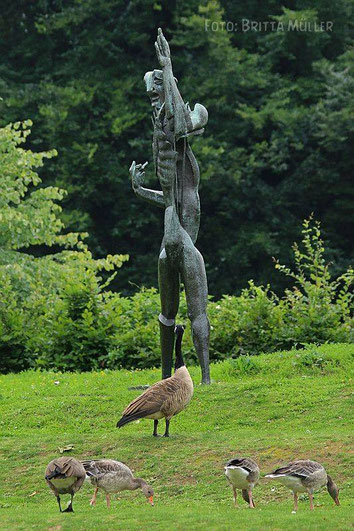 Kanadagänse schauen sich eine Skulptur an.