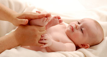 Bild eines Babys, dessen Füße massiert werden.